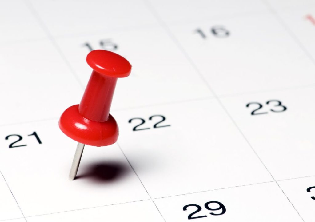 Datum im Kalender mit rotem Pin markiert
