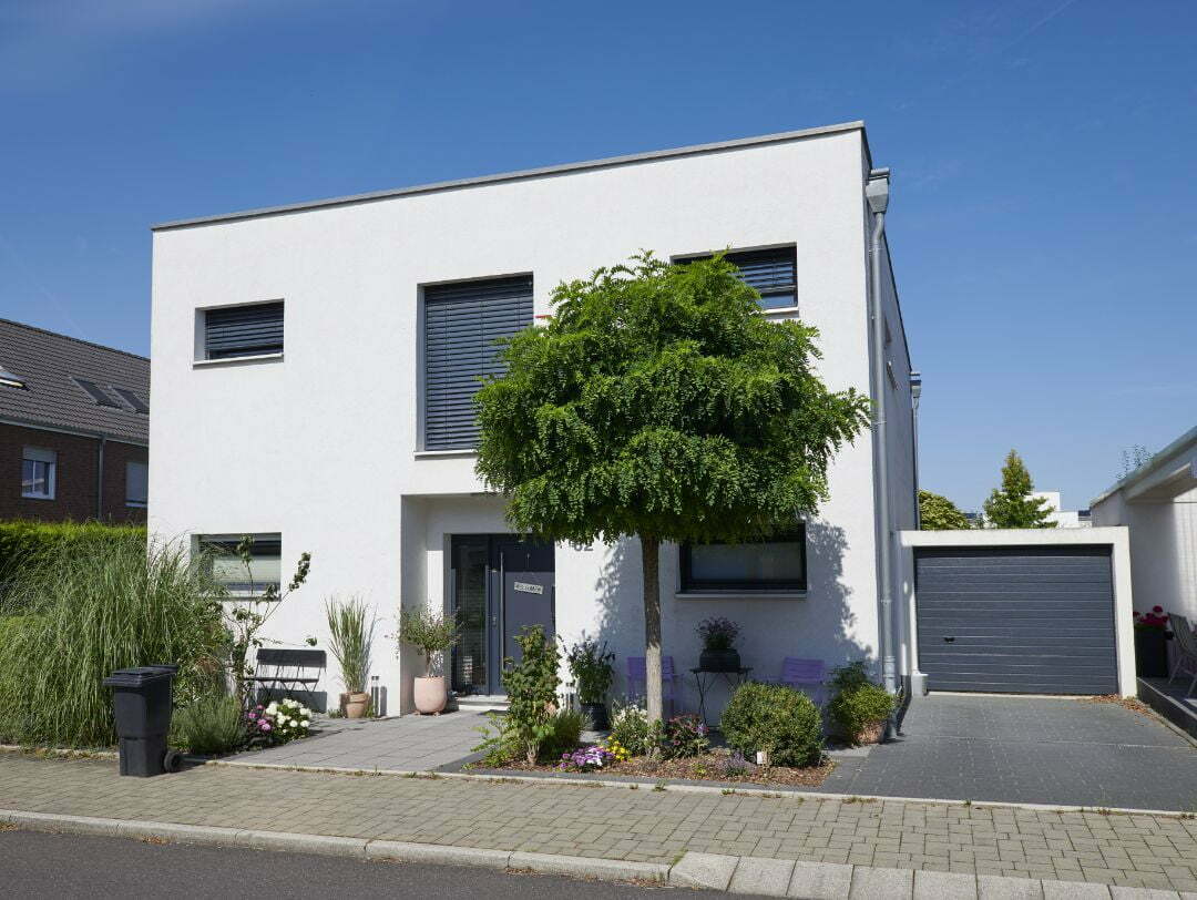 Tipps Hausverkauf, Bild zeigt einen weißen Bungalow mit schönem Garten und blauem Himmel 