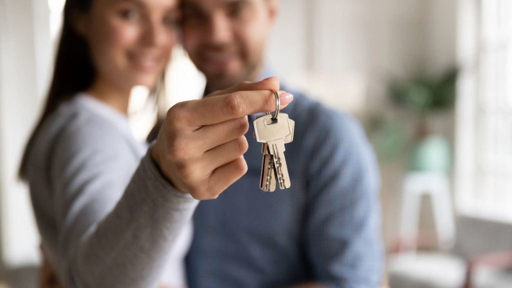 Mann und Frau nehmen Wohnungsschlüssel in Empfang