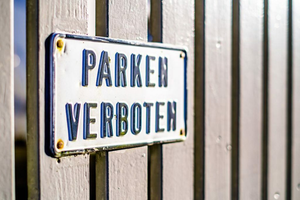 PARKEN VERBOTEN - Schild an Zaun, symbolisiert das Thema Zufahrt zugeparkt