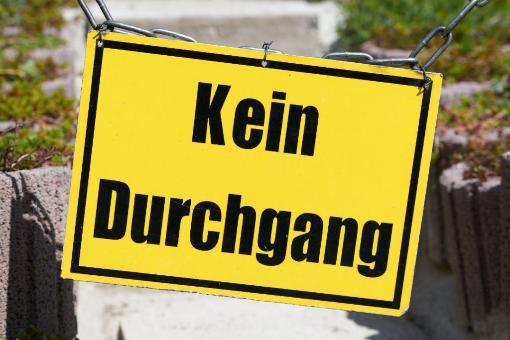 Gelbes Schild an einem gesperrten Fußweg mit der Aufschrift: Durchgang verboten, verbildlicht das Thema Wegerecht Pflichten und Rechte